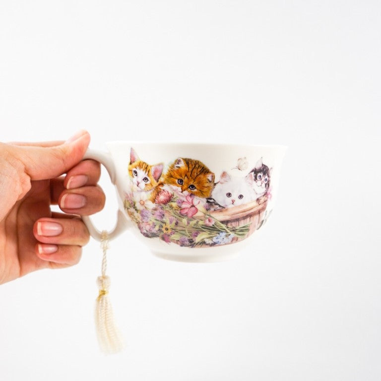 The cup has a small handle and a rope tassel tied to the handle.